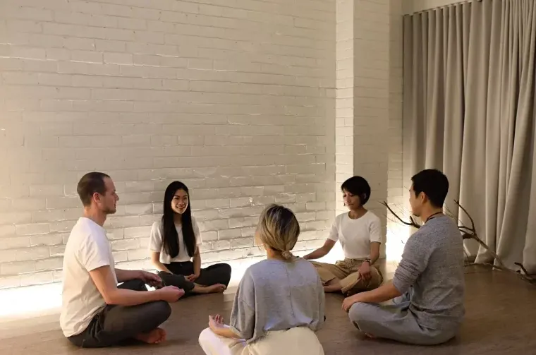 NDIS participants in a small group meditation class for mental health support.
